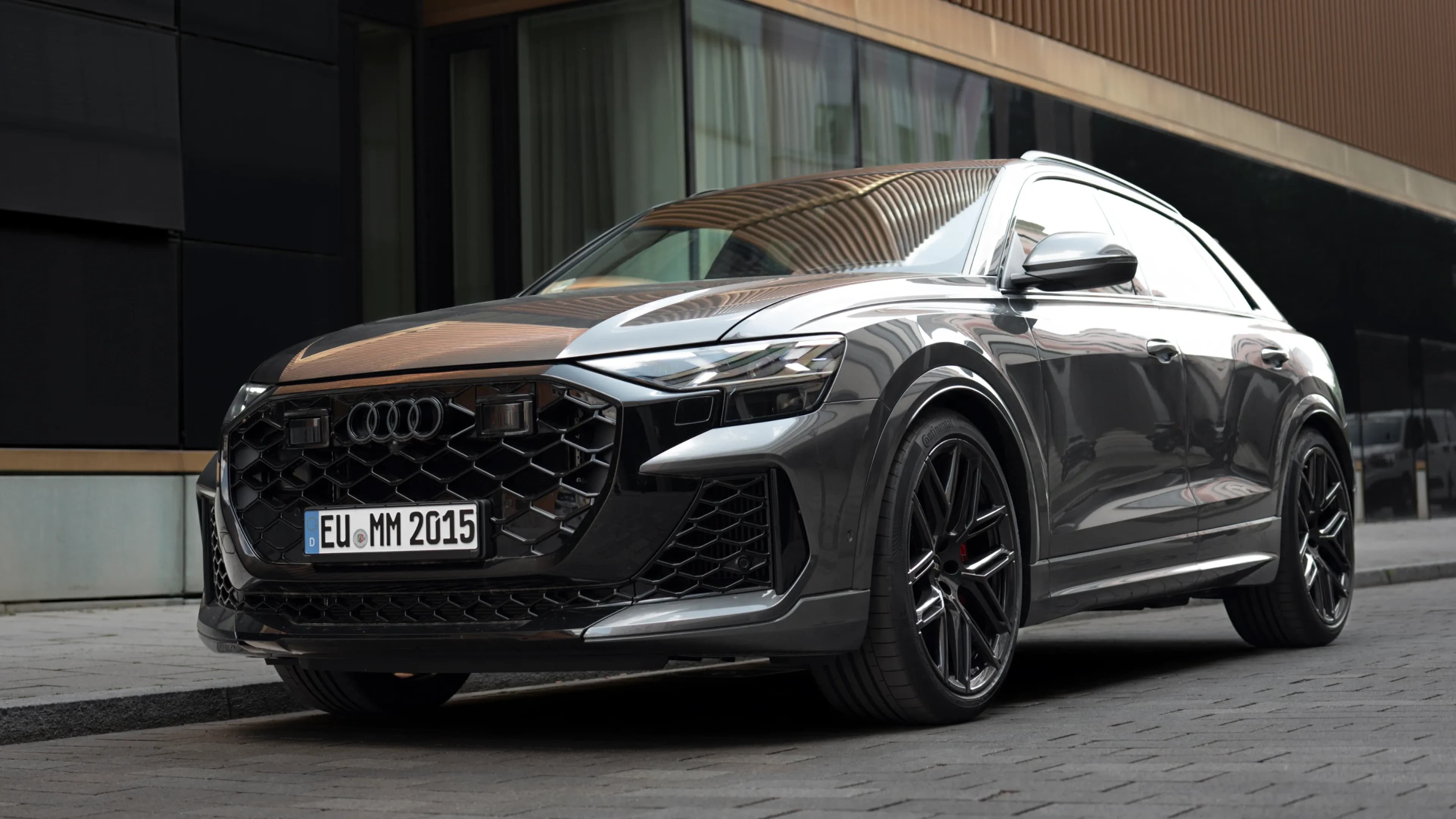 Grey Audi RS Q8 Avant from a low front three-quarter perspective on a cobblestone street in Munich by Mosaik Motors.