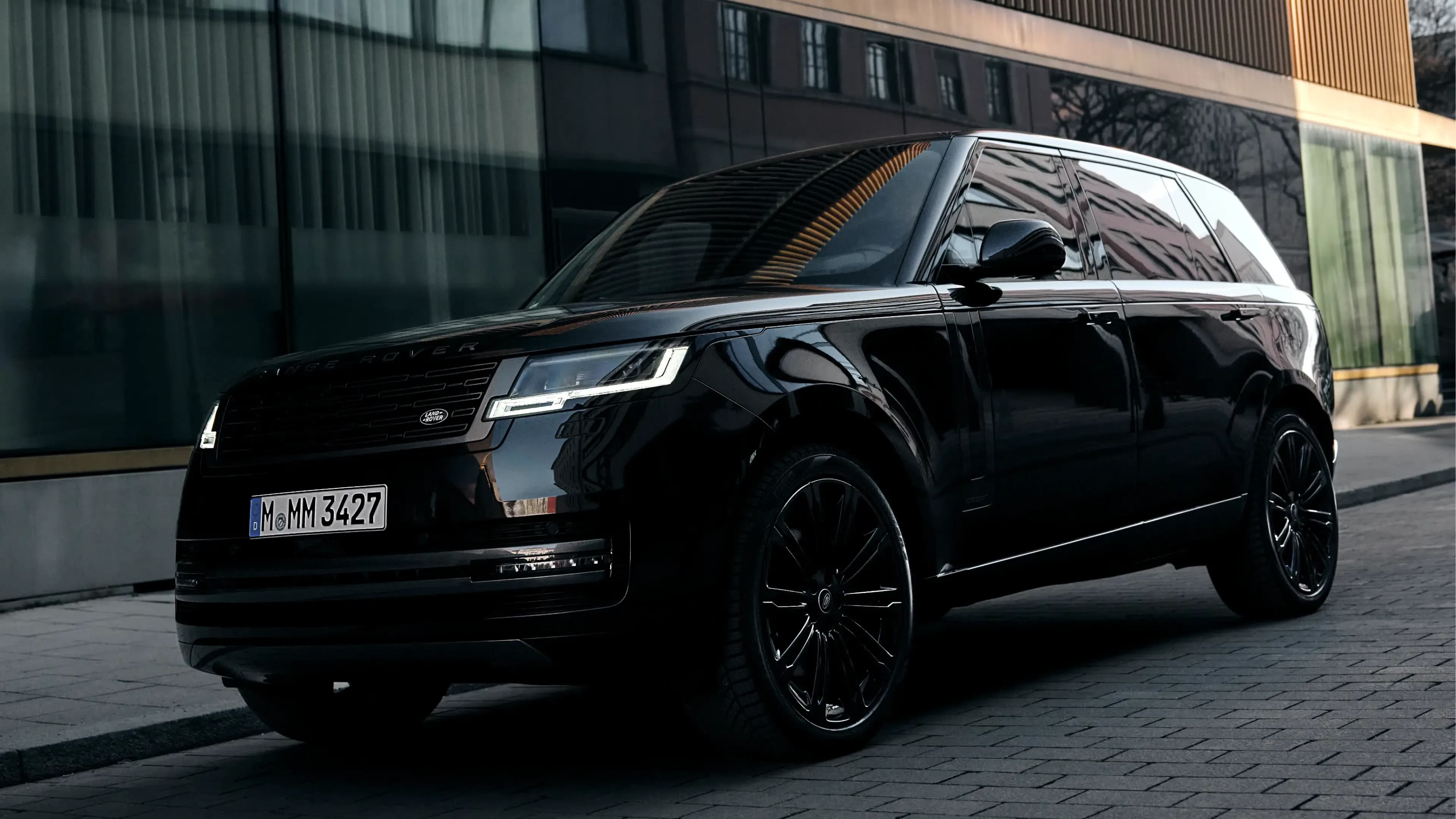 Black Range Rover Autobiography in a front three-quarter view on a Munich cobblestone street, available for luxury car rental at Mosaik Motors